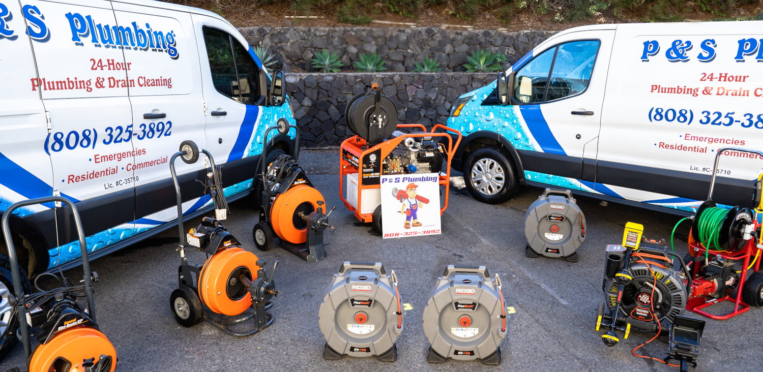 P&S Plumbing service vans with plumbing equipment and tools displayed outside.